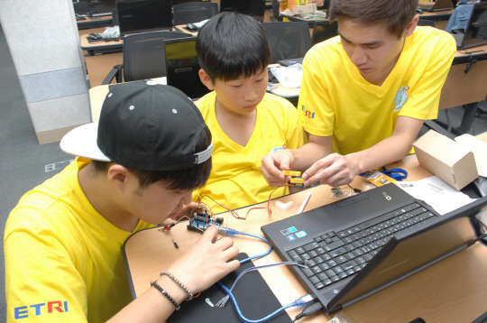 지난 19일 ETRI 본원에서 IT어린이기자단을 대상으로 열린 ICT DIY 행사에서 대학생 멘토와 어린이기자단이 아두이노를 이용해 프로그램을 제작하고 있다.  ETRI 제공